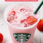 Starbucks copycat pink drink in a Starbucks cup with a green straw next to fresh strawberries.