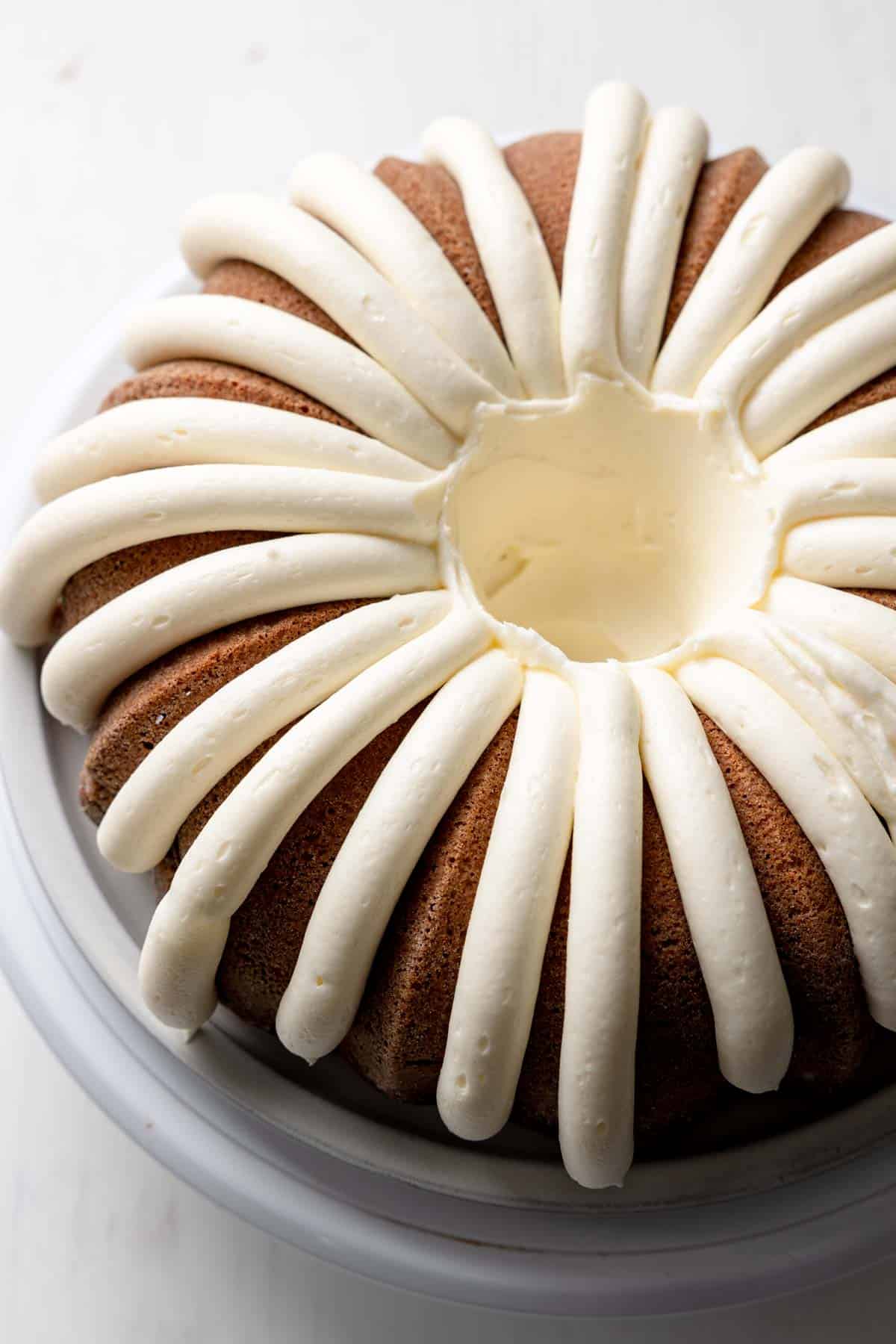 Bundt cake with lines piped all around the perimeter in the style of nothing bundt cakes.