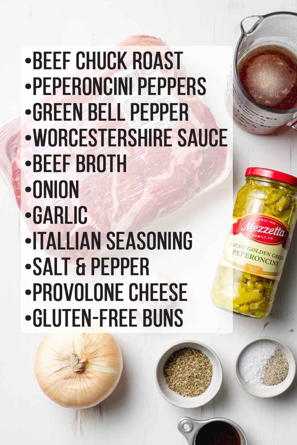 Ingredients for gluten-free Italian beef sandwiches laid out on a white wooden surface. 