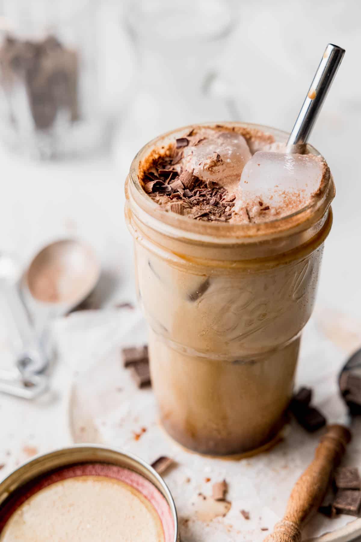 Mason jar filled to the brim with chocolate espresso and garnished with chocolate shavings. 