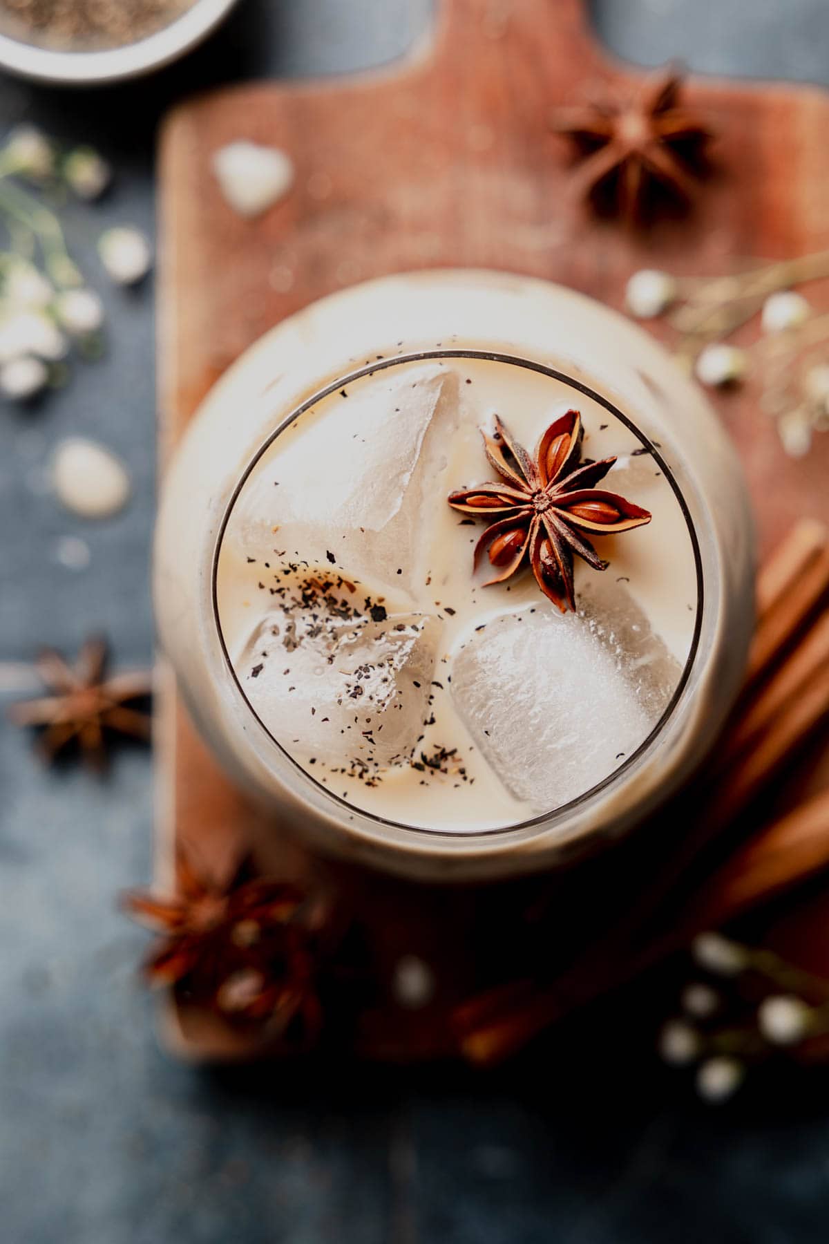 Overhead view of chai latte in glass with star anise garnish.