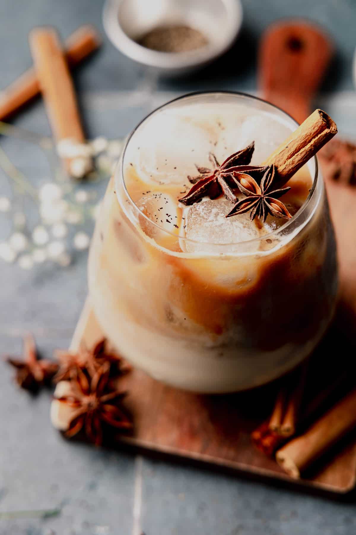 Iced Dirty Chai Latte in a glass, garnished with star anise and cinnamon stick.