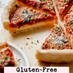 Gluten free Chicago deep dish pizza with sauce on top, sliced and resting on parchment paper, sprinkled with parmesan and parsley.