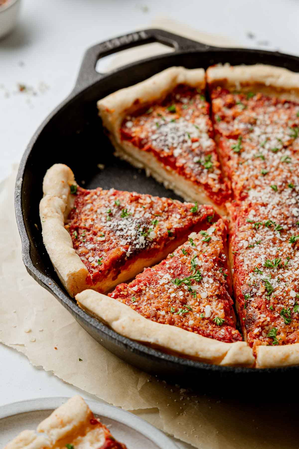 Gluten free deep dish pizza in a cast iron pan, sliced.