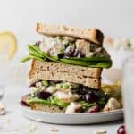 A stack of gluten-free chicken salad sandwiches with grapes and lettuce peeking out.