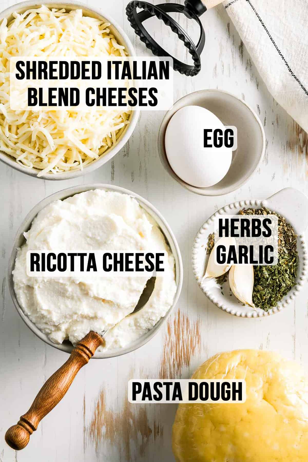 Ricotta cheese and shredded cheeses in a bowl next to egg, garlic, and herbs.