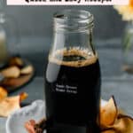 Small recycled Starbucks jar filled with homemade apple brown sugar syrup, on apple plate garnished with apple chips and cinnamon sticks.