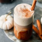 Starbucks iced pumpkin cold brew coffee garnished with pumpkin spice and a cinnamon stick.