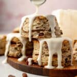 A stack of gluten-free cinnamon raisin biscuits with icing dripping down.