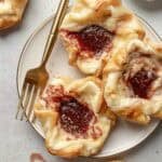 Three Starbucks copycat sugar plum danish o a small plate next to a fork and coarse sugar.