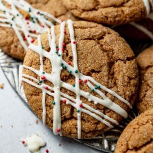 A plate full of gluten free ginger molasses cookies decorated with chocolate stripes and sprinkles.