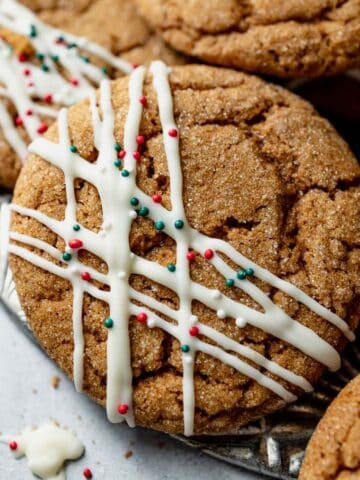 A plate full of gluten free ginger molasses cookies decorated with chocolate stripes and sprinkles.
