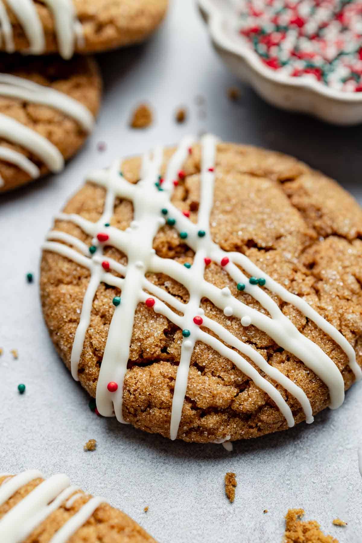Gluten Free Ginger Molasses Cookie adorned with white chocolate and red and green sprinkles.