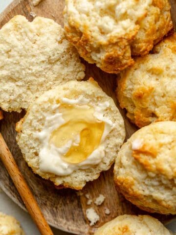 Open face gluten-free drop biscuit slathered with butter and honey.