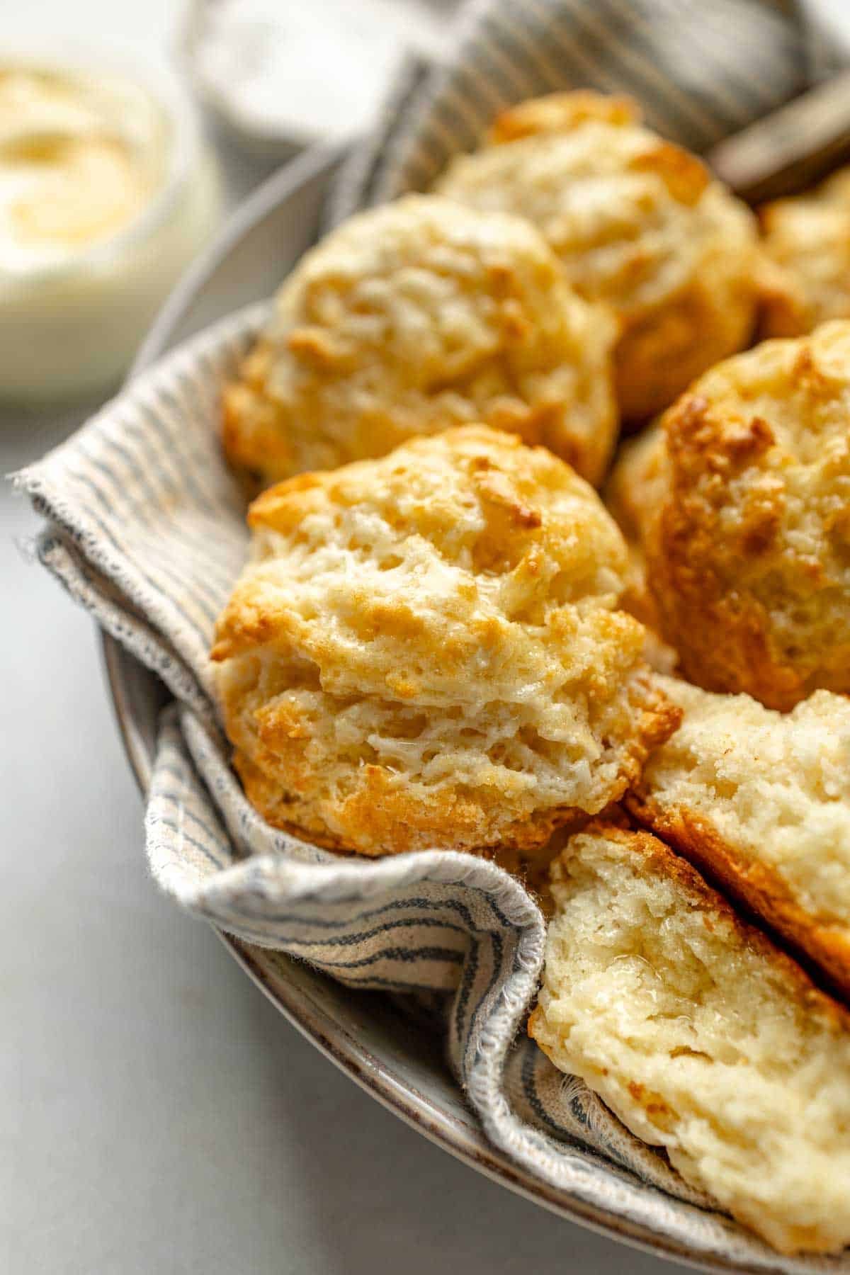 Biscuits sans gluten dans un bol recouvert d'une serviette rayée.