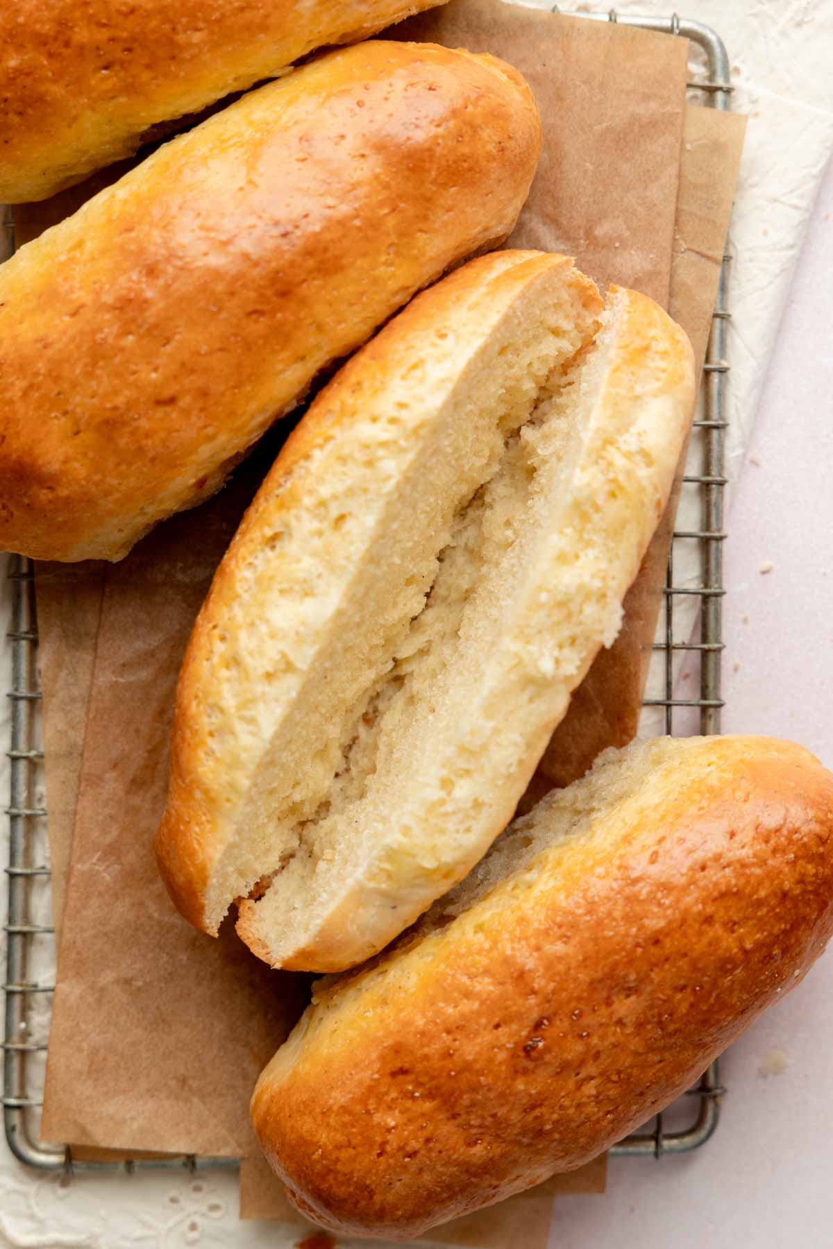 Close-up top-down shot of a sliced gluten-free hot dog bun, showing the soft inside texture and golden brown exterior.