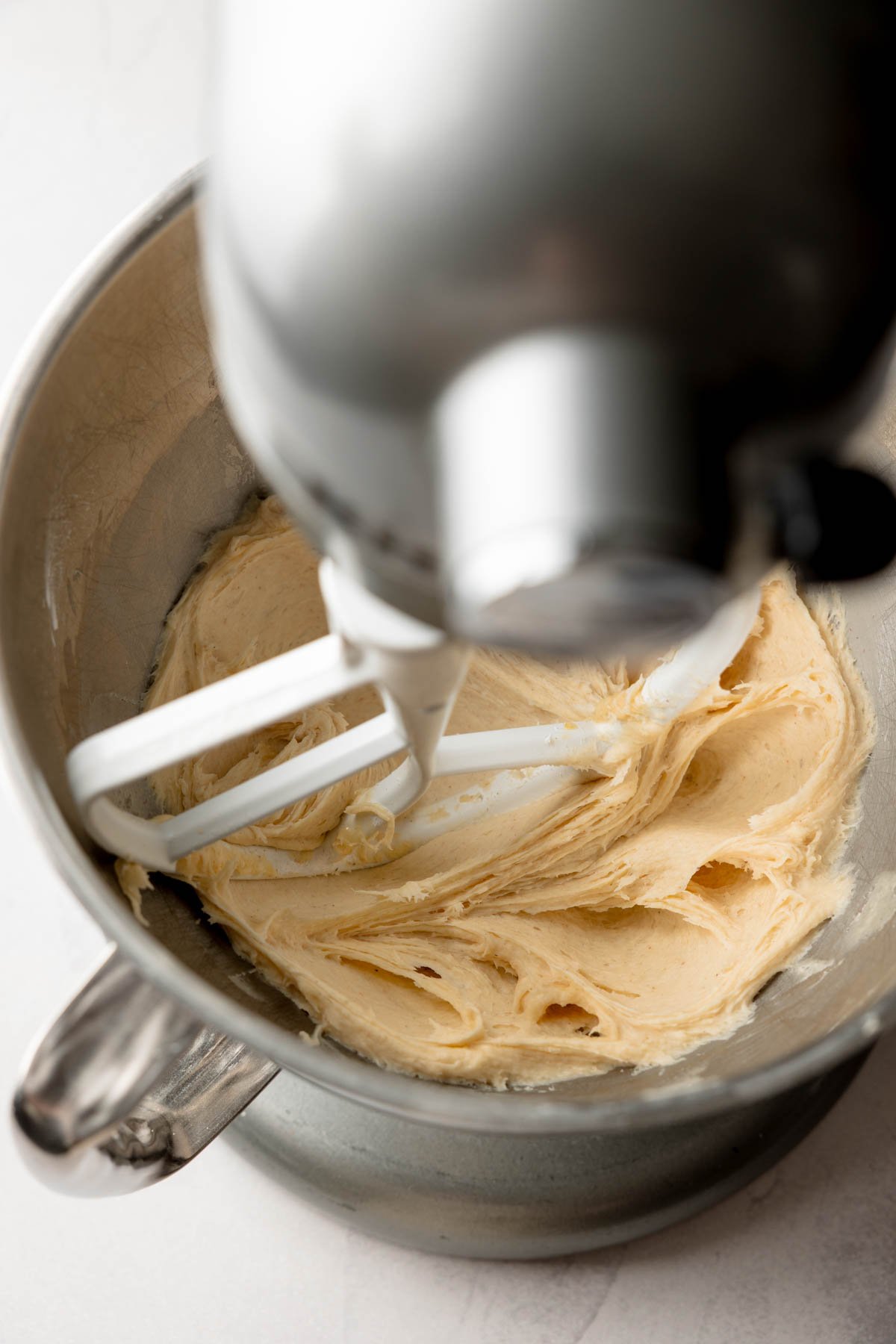 Gluten-free dough fully mixed in a stand mixer bowl with a smooth and slightly sticky texture.