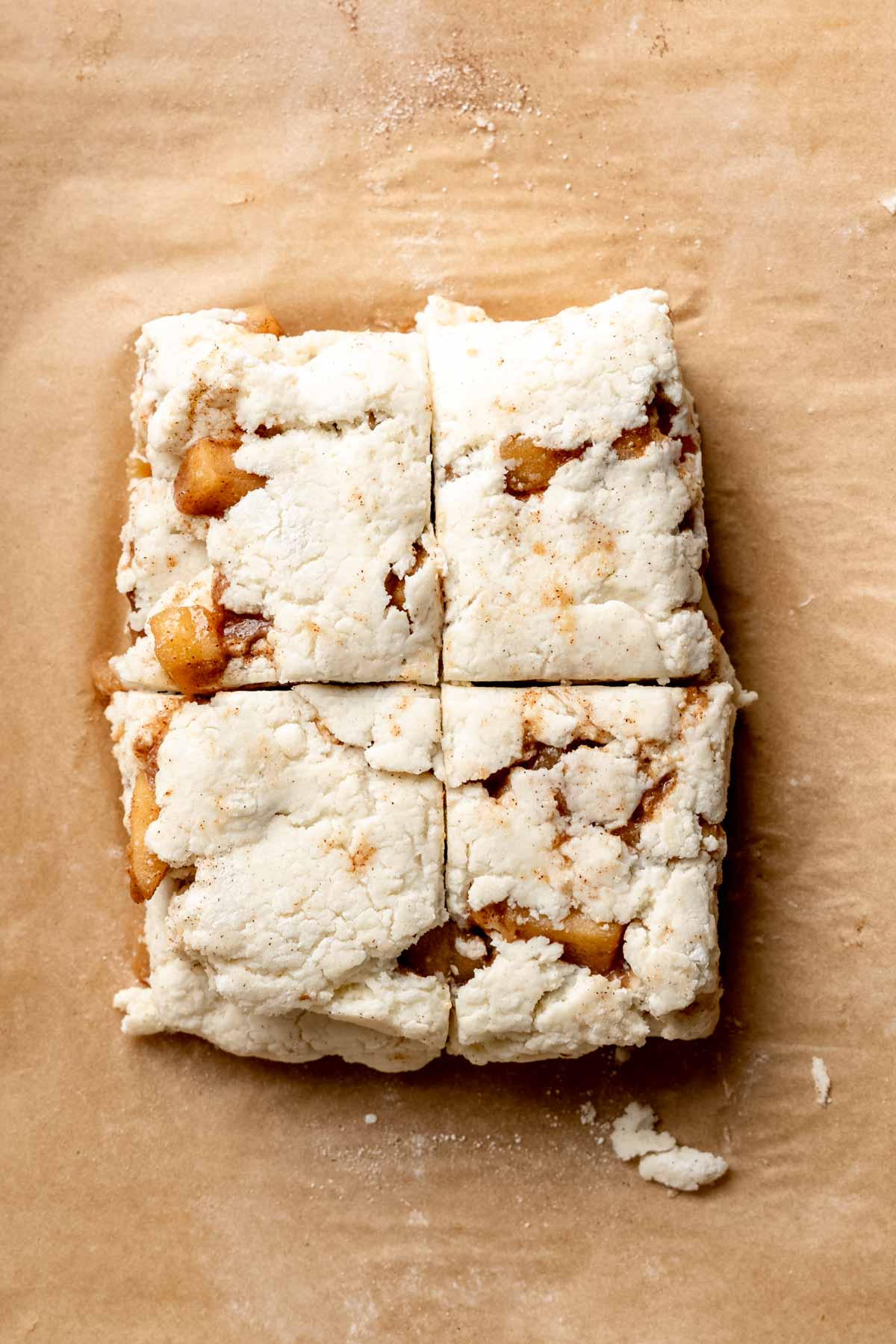 Apple pie biscuit dough cut into four squares.