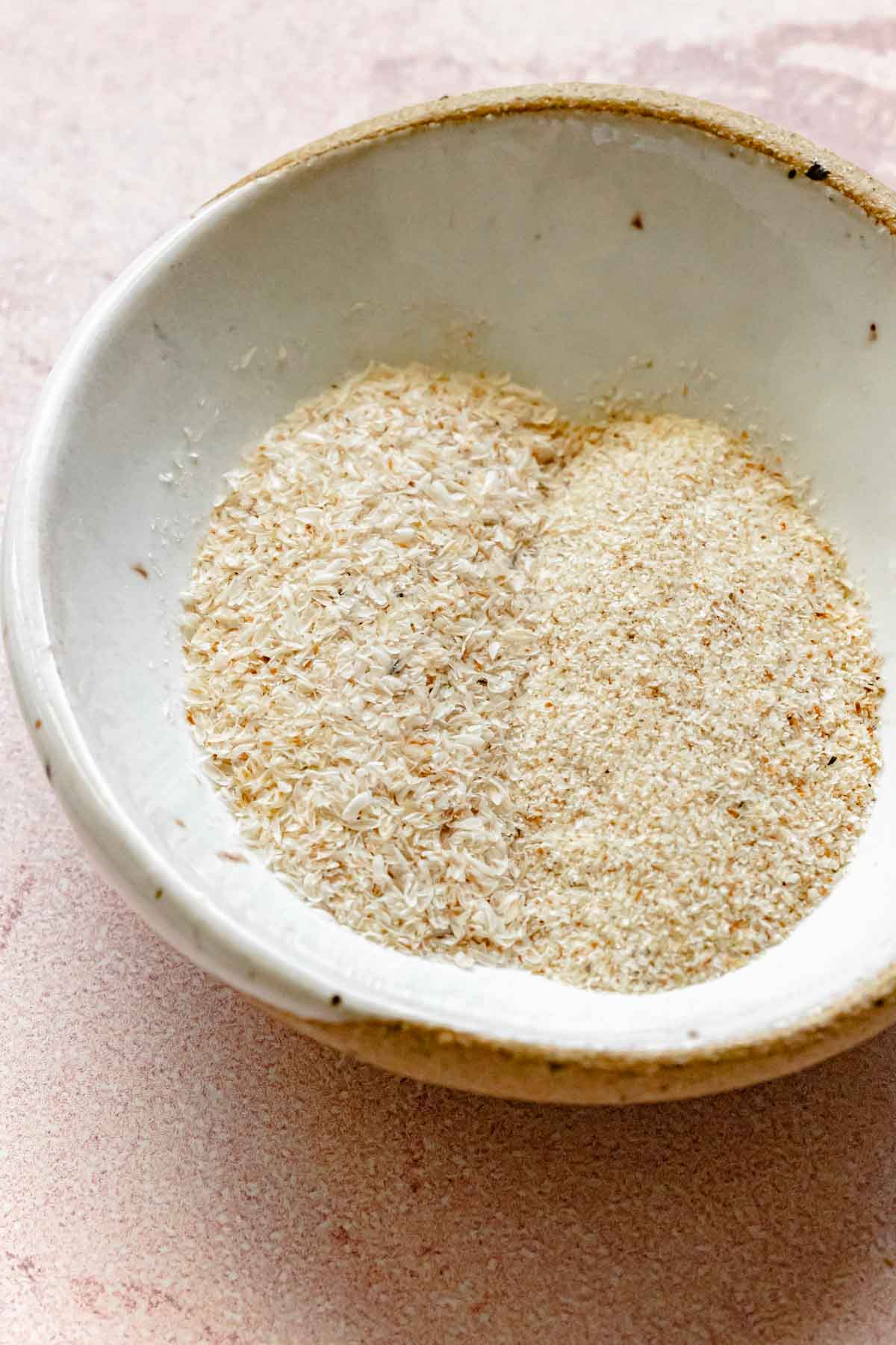 Small dish with whole psyllium husk on one side and powdered psyllium husk on the other.