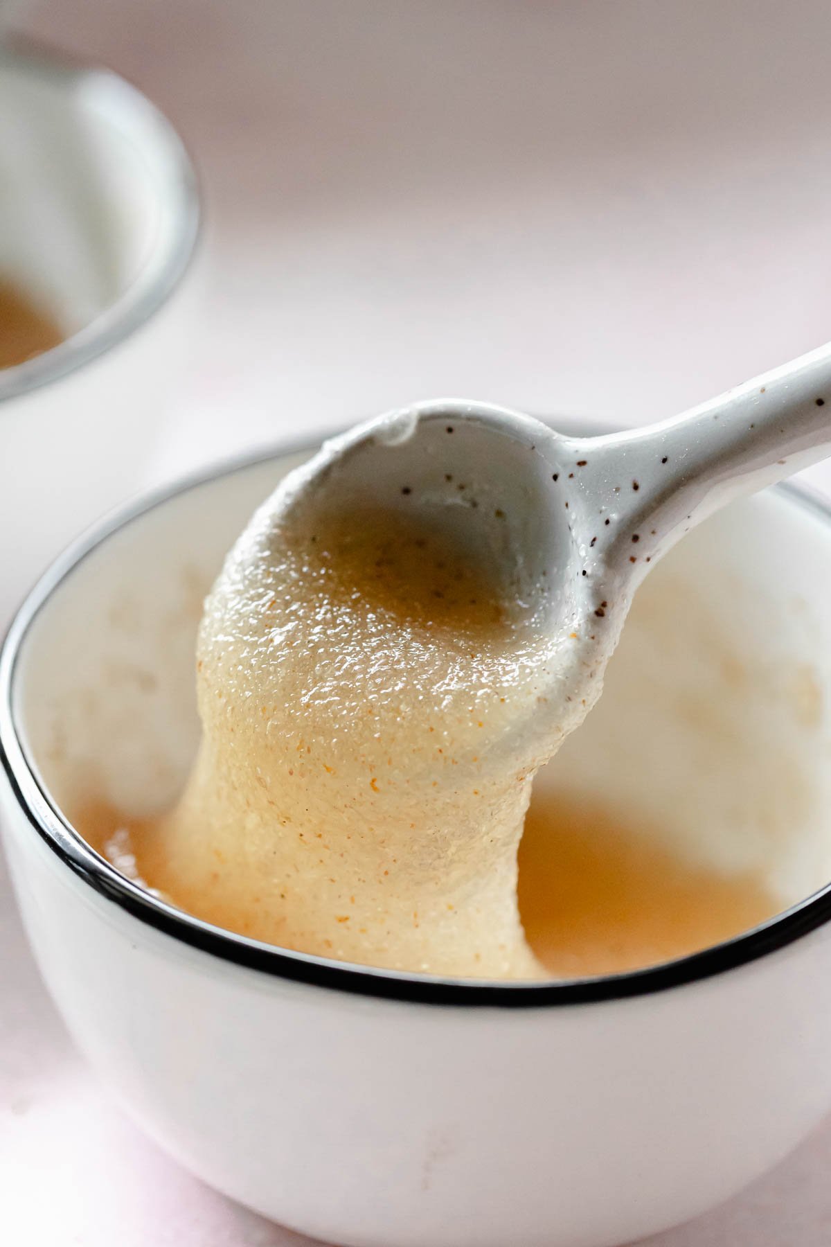 Psyllium husk powder gel in small bowl lifted by spoon.