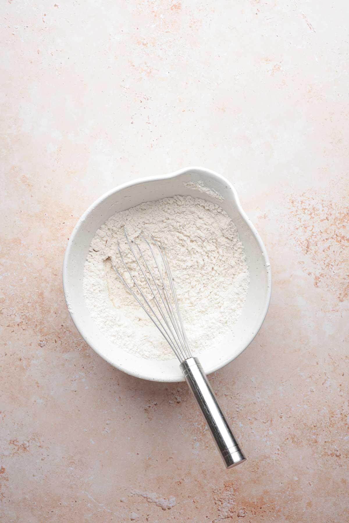 Bowl of gluten-free flour with whisk.