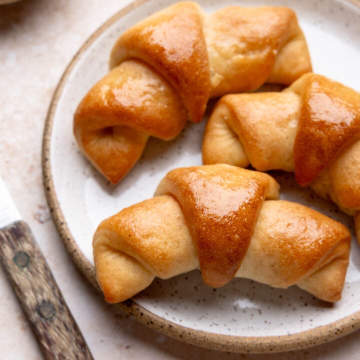 Plate with three golden brown baked gluten-free crescent rolls.