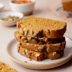 Slices of gluten-free pumpkin bread stacked on small plate.