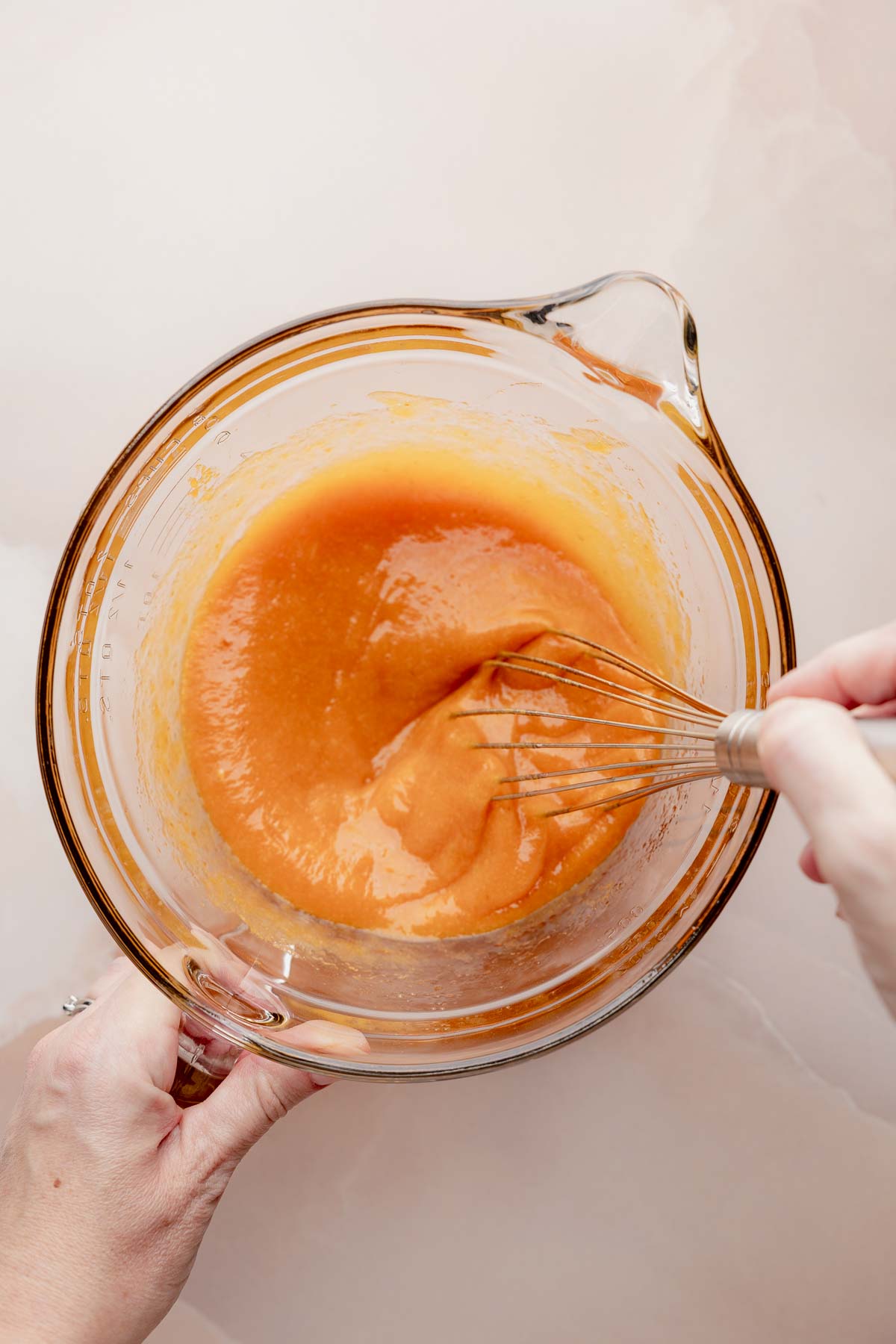 Mixing bowl with pumpkin batter and whisk for gluten free pumpkin bread.