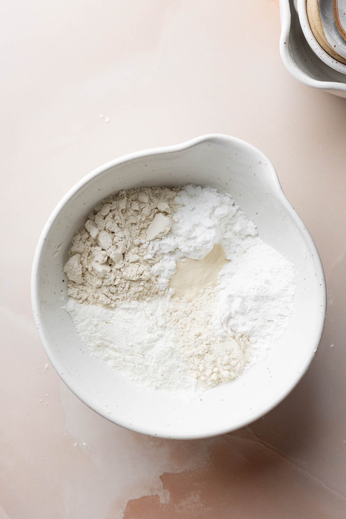 Gluten-free flours and starches measured out in a large mixing bowl.