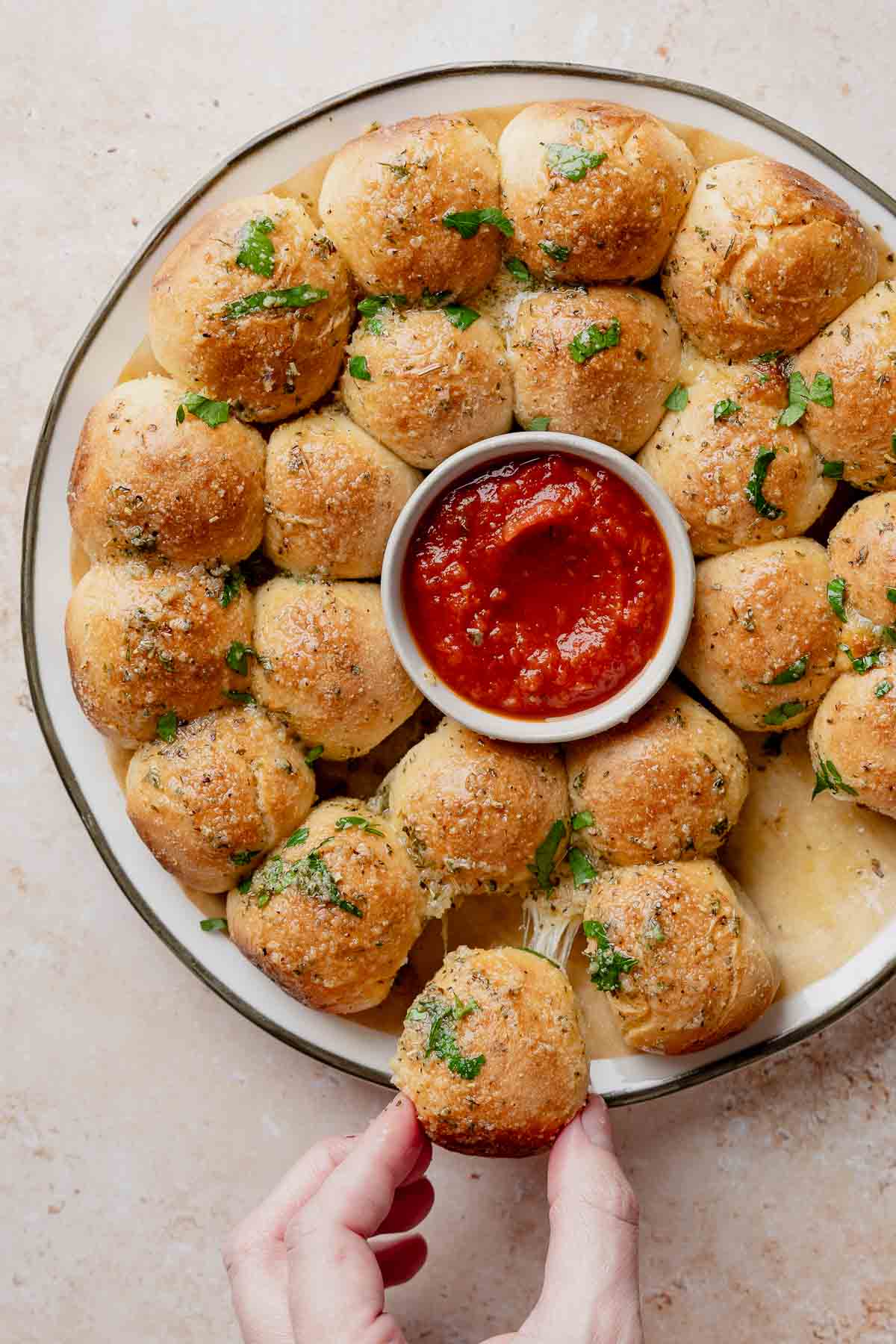 Gluten-free cheesy garlic pull apart bread baked into a wreath with marinara dipping sauce.
