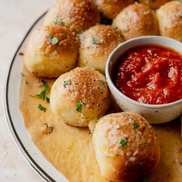 Gluten-free cheesy garlic pull apart bread with marinara dipping sauce in center.
