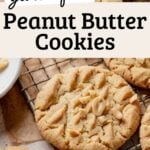 Baked peanut butter cookies on a cooling rack with chopped peanuts on top.