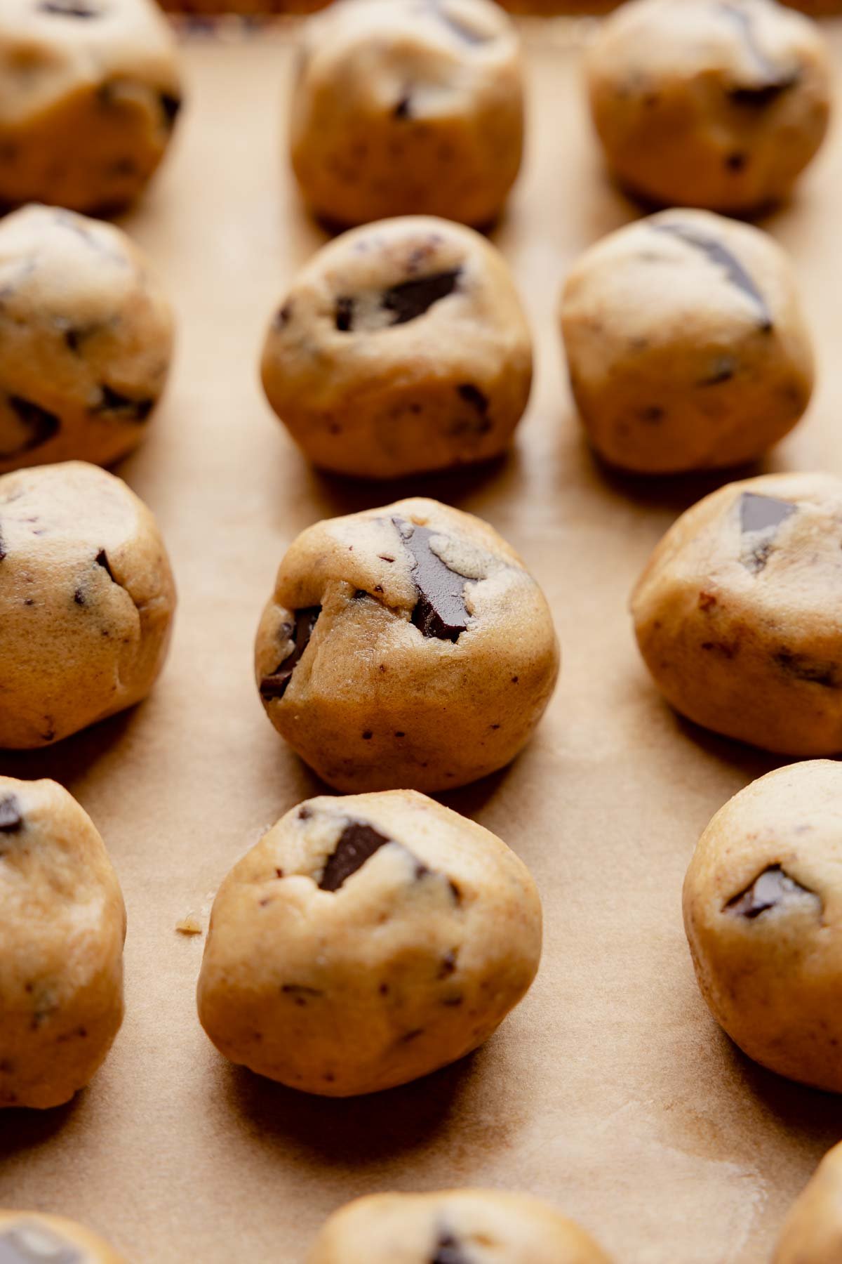 Peanut butter chocolate chip cookie dough balls on a baking sheet.