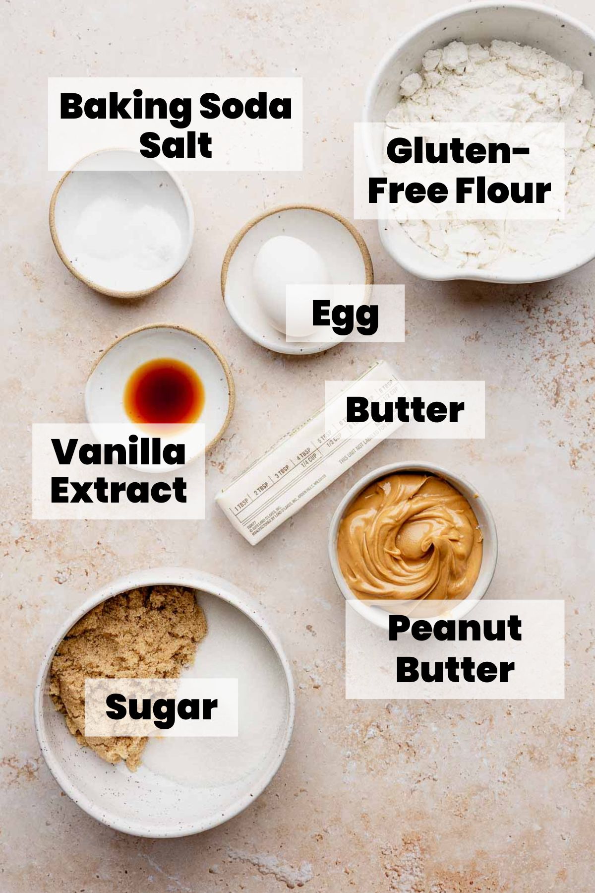 Bowls of labeled ingredients: peanut butter, gluten-free flour, sugar, egg, butter, vanilla, baking soda, salt.