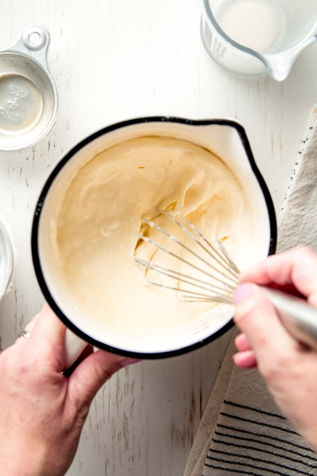 Heavy cream, sour cream, and eggs whisked together in a bowl.