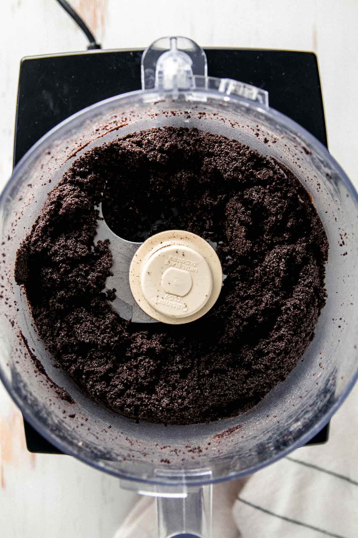 Gluten-free Oreo crumbs in food processor bowl. 