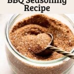 Homemade bbq seasoning blend in glass jar with gold measuring spoon.