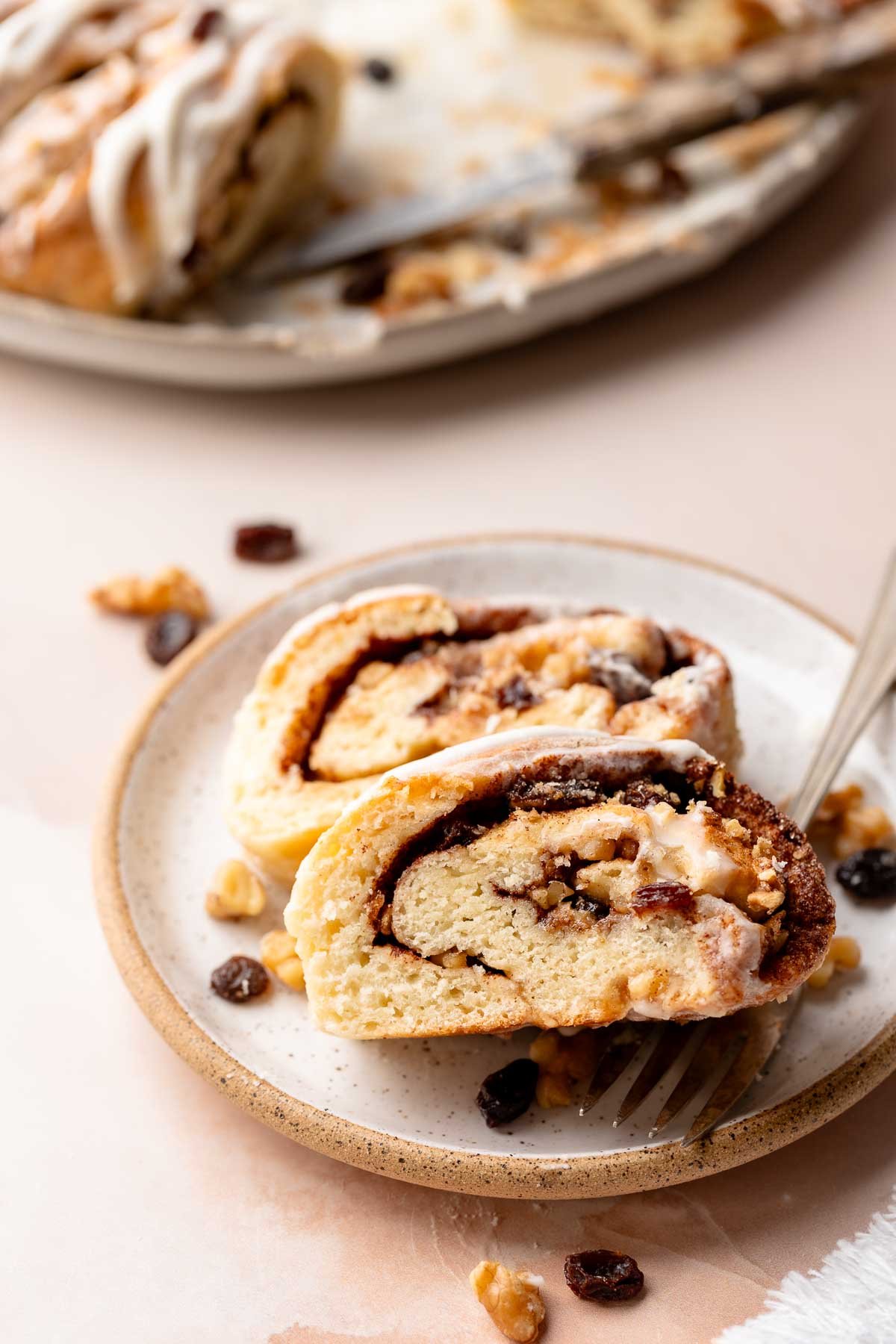 slices of swedish tea ring on plate, sprinkled with raisins and walnuts.
