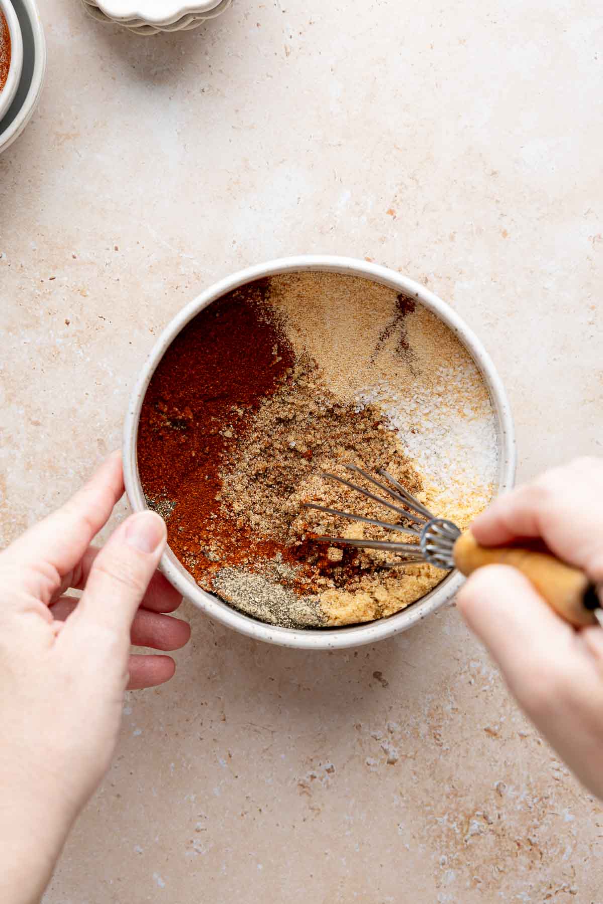 Bbq seasoning ingredients in a bowl, mixing with whisk.
