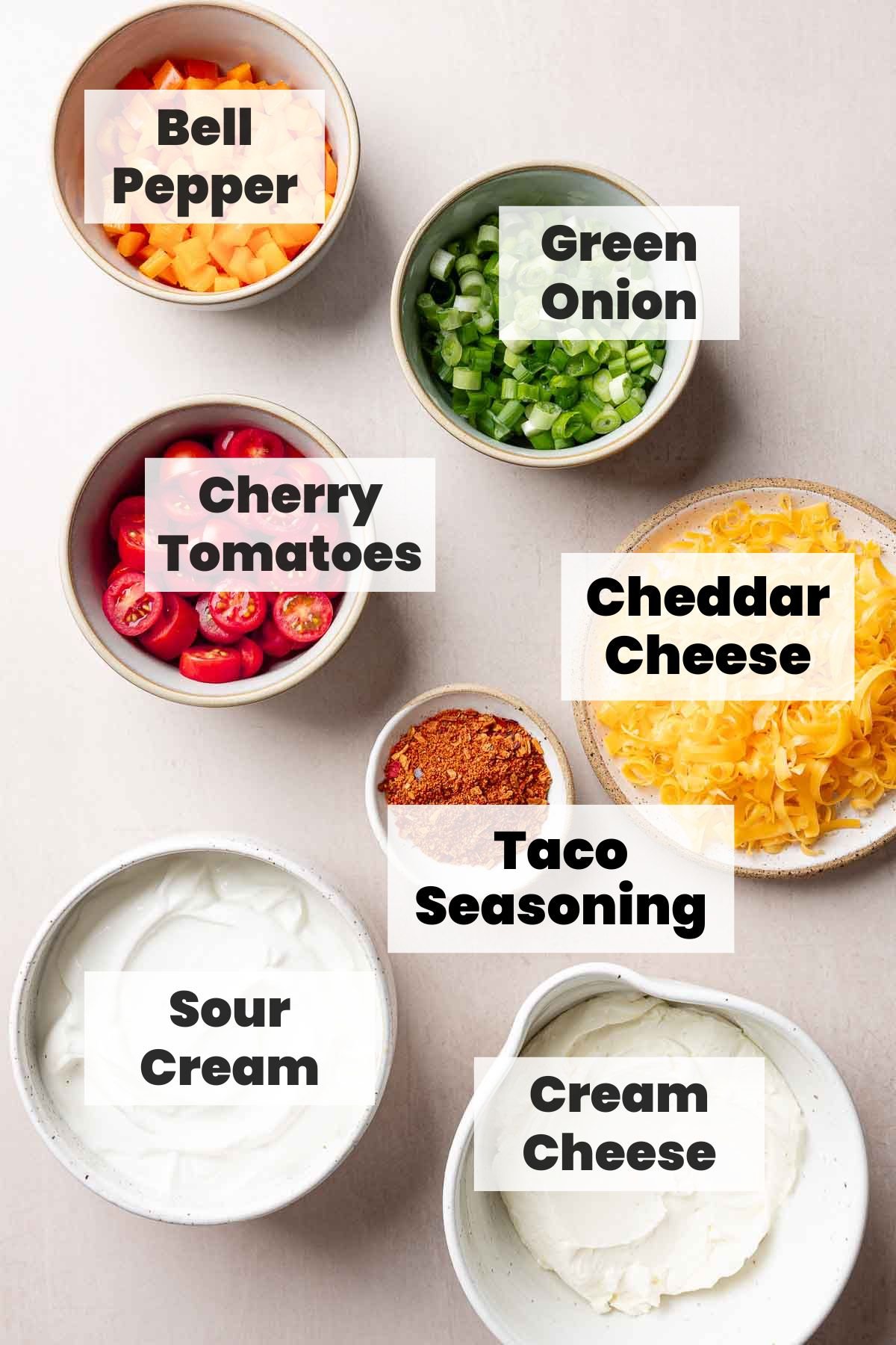 Ingredients for taco dip with cream cheese measured out in bowls.