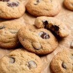 Almond flour chocolate chip cookies strewn about brown parchment paper.