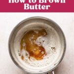 Brown butter with deep golden toasted milk solids visible beneath the foam in a saucepan.