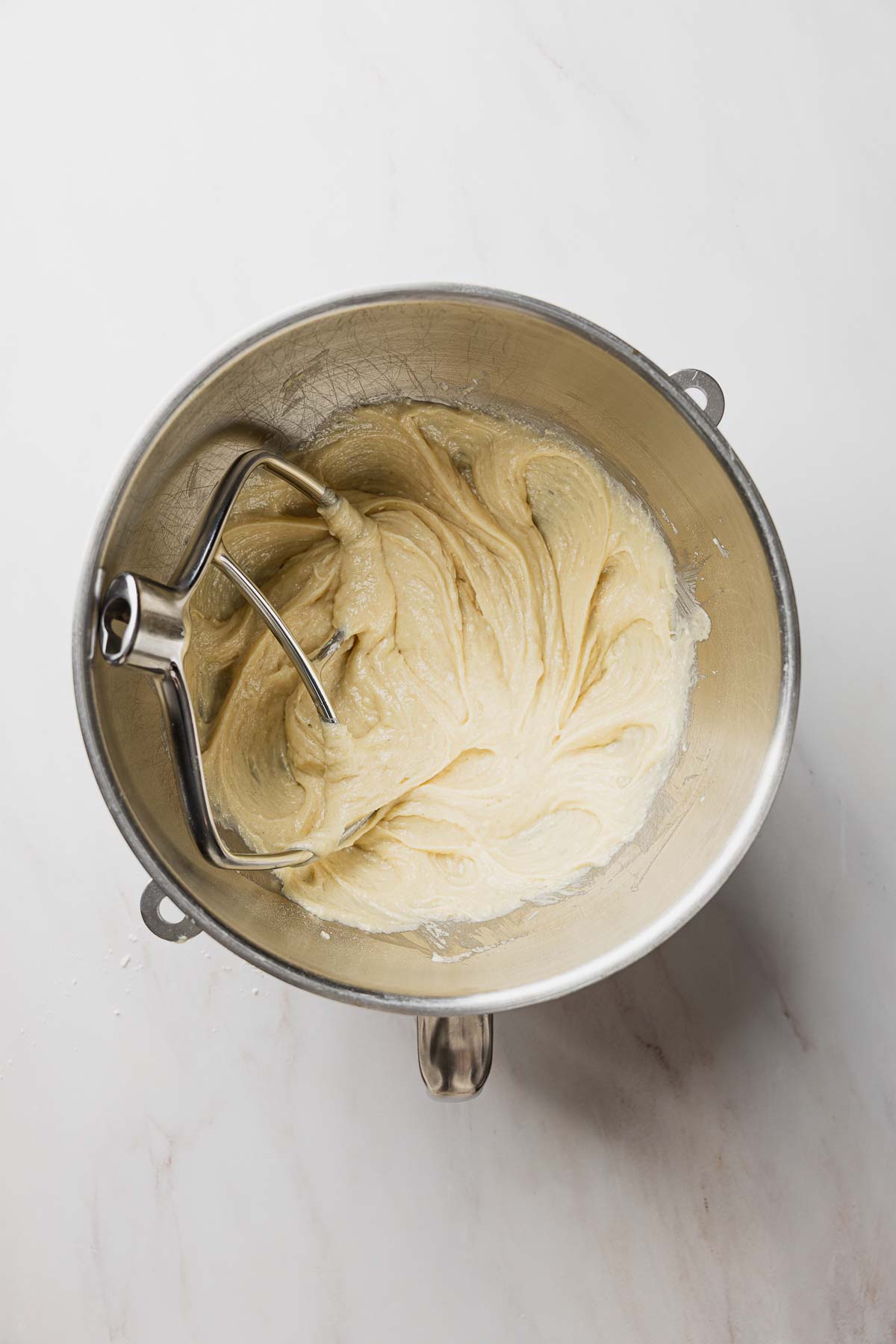 Blueberry muffin batter mixed together in stand mixer bowl.