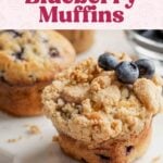 Gluten-free blueberry muffins with streusel and garnished with fresh blueberries, on marble platter.