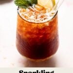A sparkling Americano in a glass with ice, garnished with fresh mint and a lemon slice.