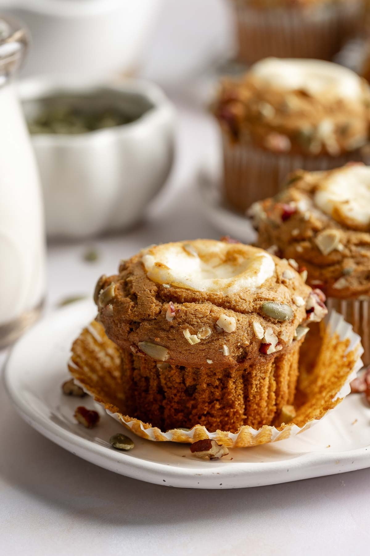 Starbucks cream cheese muffin on small plate, garnished with pepitas.