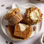 Gluten-free Starbucks cream cheese muffins on small pumpkin shaped plate, one sliced open to show filling inside.