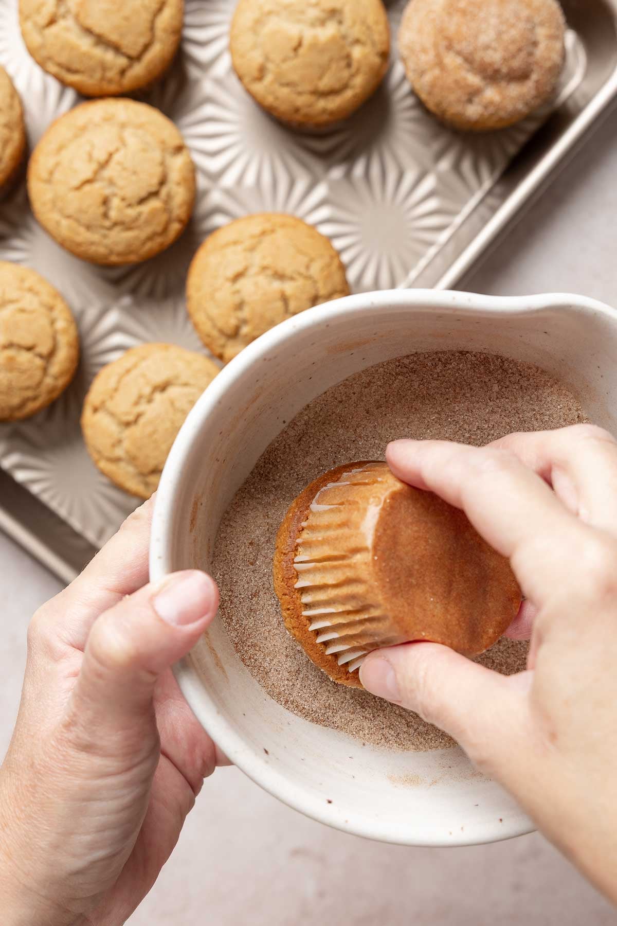 Muffin top is rolled in cinnamon-sugar mixture.