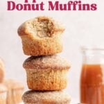 A stack of gluten-free apple cider donut muffins on a small white plate, a jar of apple cider in the background.