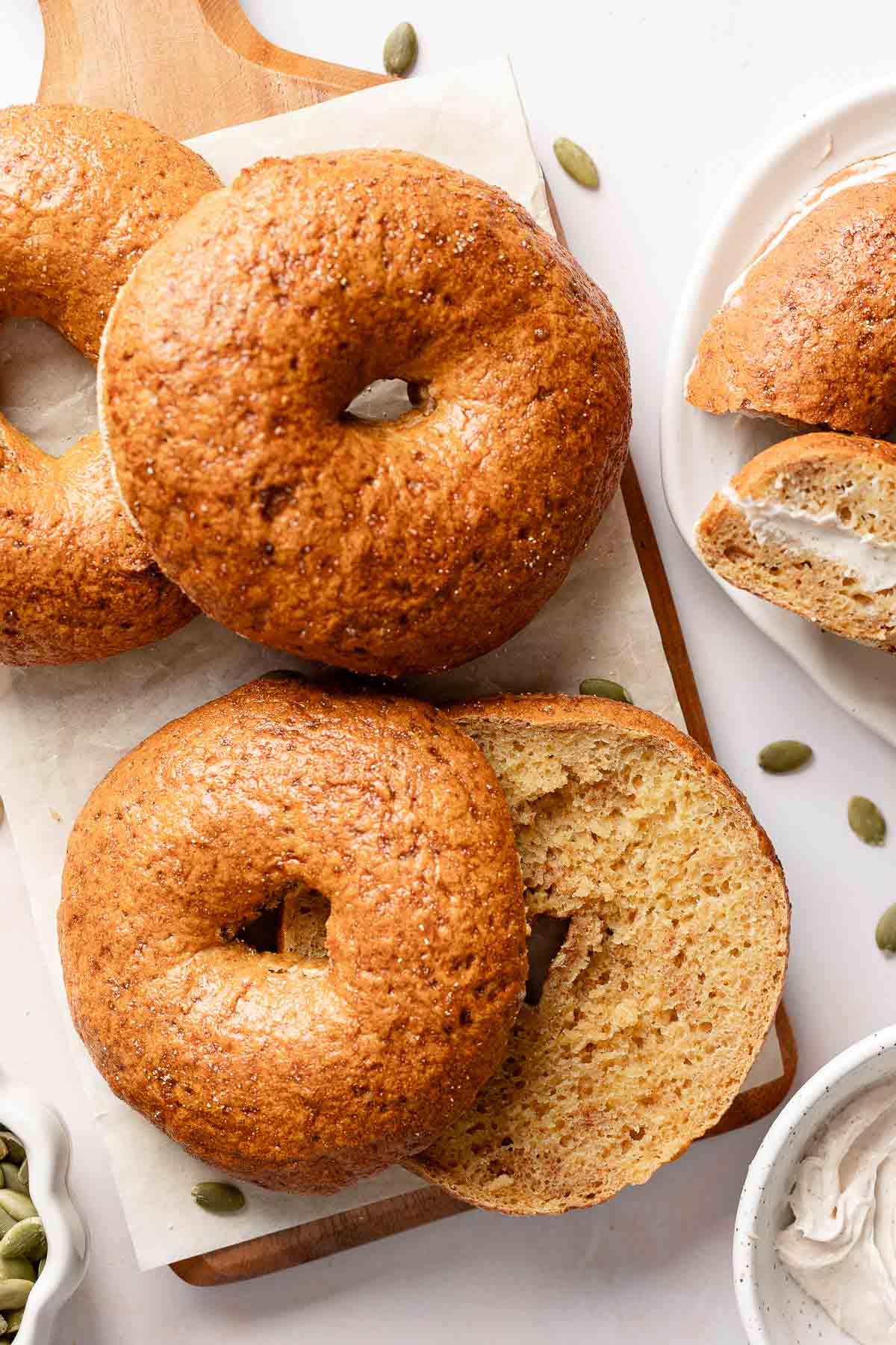 Gluten-free pumpkin bagels arranged on a small board.